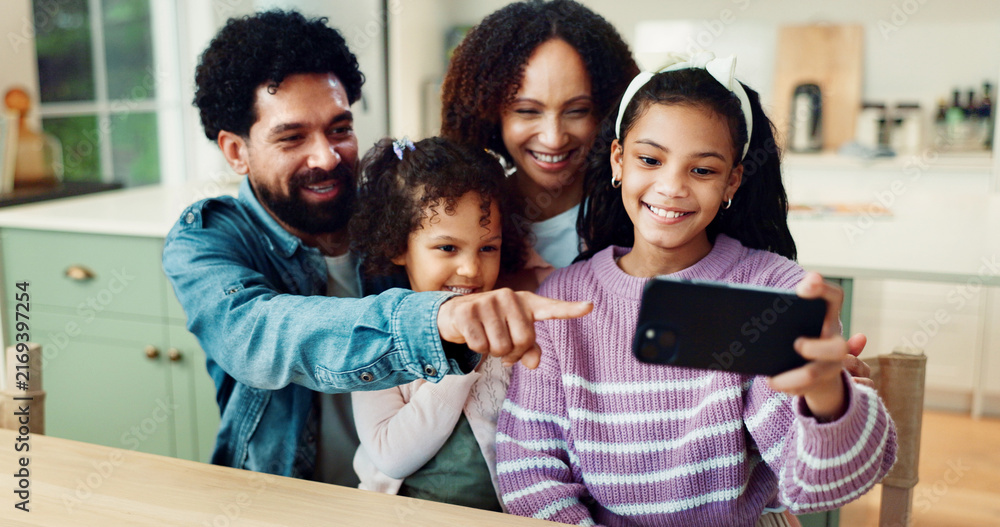 Obraz premium Family, happy and pointing with selfie in home for photography, memory or weekend together. Mom, dad and kids with smile, picture or capture moment for bonding, holiday or social media post in house