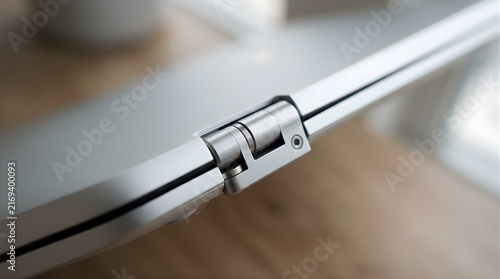 Silver metal laptop hinge mechanism close up with blurred background