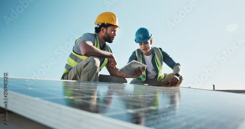 Technician, team and outdoor at solar panel with tablet, planning upgrade or innovative design. Men, talking and tech with photovoltaic grid for project management with energy source at eco building