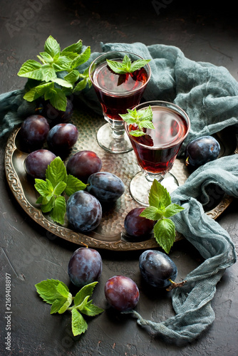Shot glasses with  plum liqueur and fresh fruits, selective focus