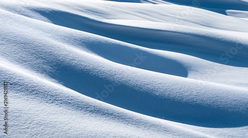 Wavy snow dunes with soft shadows in bright daylight winter landscape