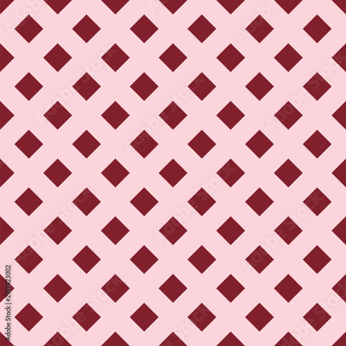 Seamless pattern created from small dark pink diamonds on a pale pink background