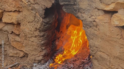 Close up of bright flames burning inside a traditional stone oven for grape scalding escalda tradition in slow motion.