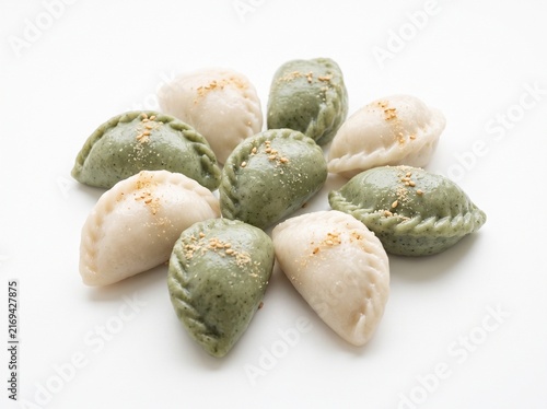 Traditional Korean Songpyeon rice cakes, crescent shaped steamed dumplings on white background