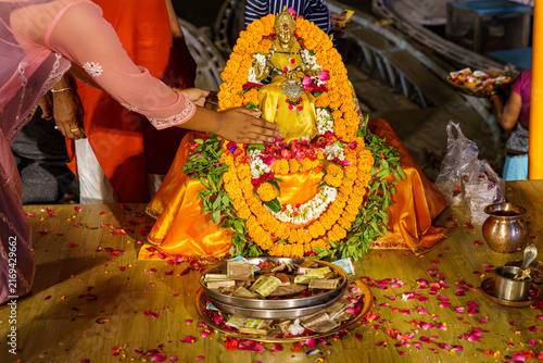 India. State of Uttar Pradesh. Varanasi. A devotee places her hand in blessing on a statuette of the goddess Ganga (or Lakshmi) during the Ganga Aarti ceremony