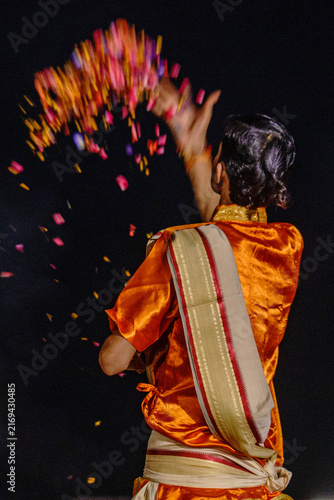 India. State of Uttar Pradesh. Varanasi. A Hindu priest tosses flower petals into the air as a sacred offering during the Ganga Aarti ceremony