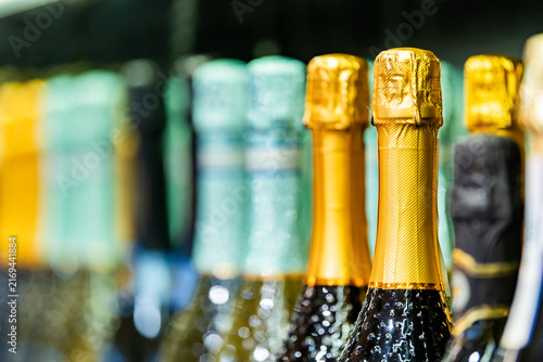 Obraz na plátně Colorful champagne bottle collection with metallic foil tops