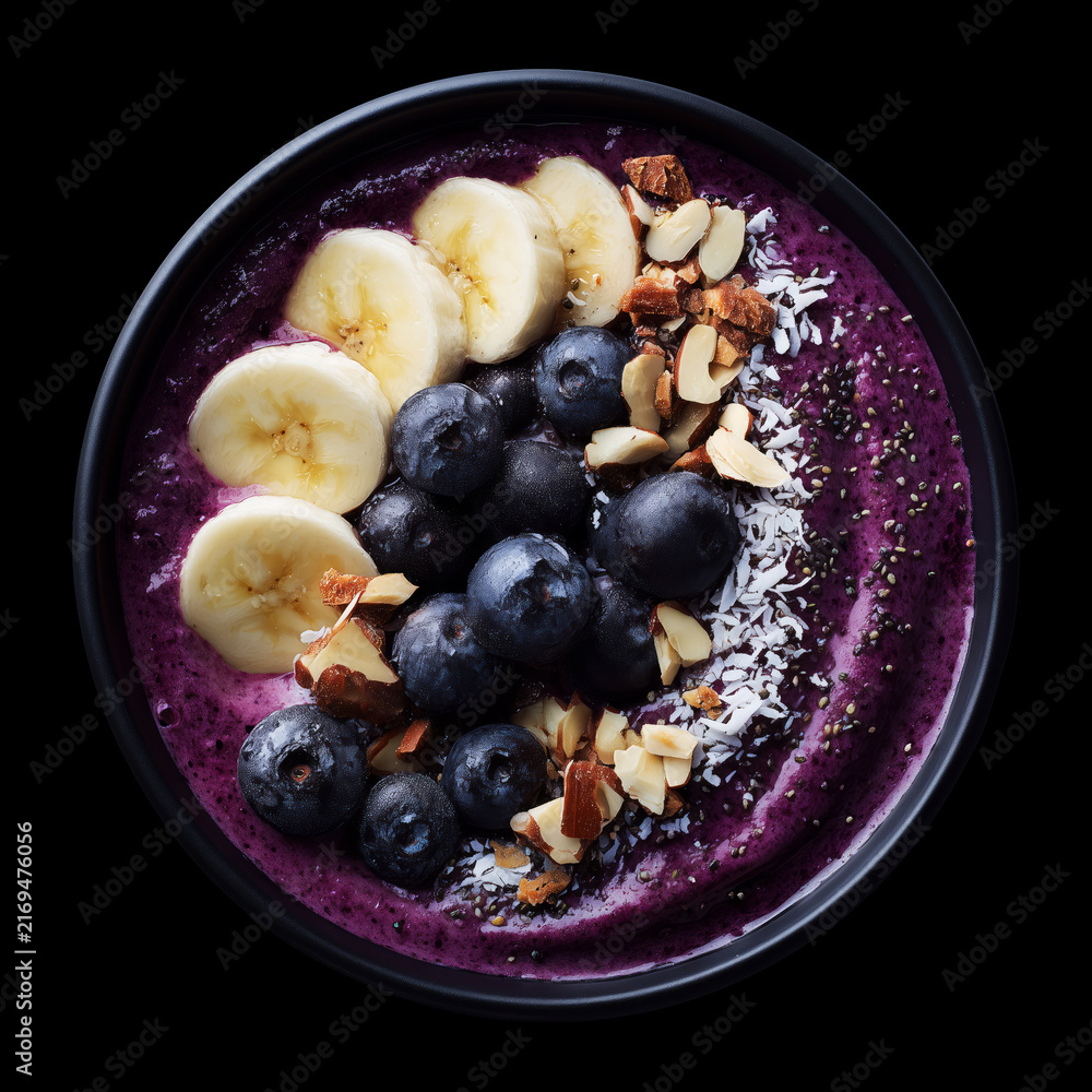 Obraz premium Fresh acai bowl with banana, berries, and nuts isolated on black backdrop with clipping path, symbolizing healthy nutrition