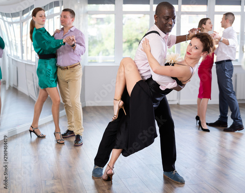 Cuadro en lienzo Active middle-aged lady training waltz in pair with man in dance-hall during dan