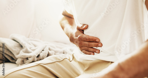 Bild auf Leinwand Man, hands and sick on sofa with stomach ache, allergy or constipation from irritable bowel syndrome