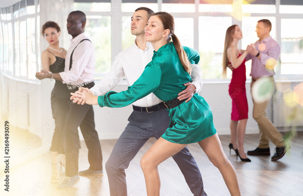 Fototapeta premium Elegant couples dancing tango, enjoying dance moves in dance salon