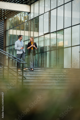 Foto Business colleagues walking downstairs talking during coffee break