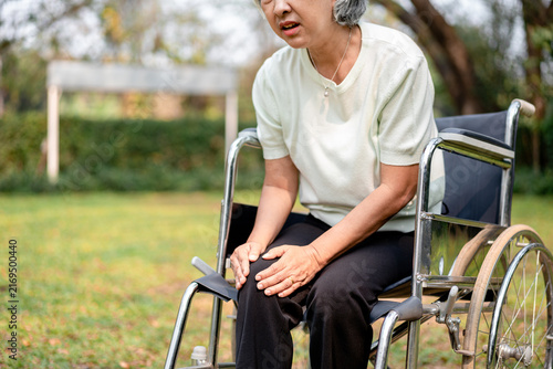 Canvastavla Older Asian Woman with Knee Pain Sitting on Wheelchair in Garden Healthcare Mobi