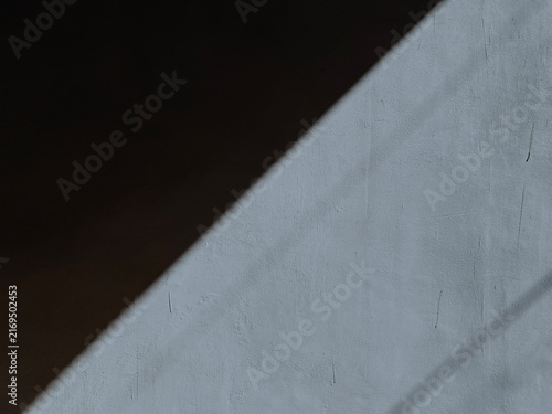Diagonal shadow stripe on white wall background.