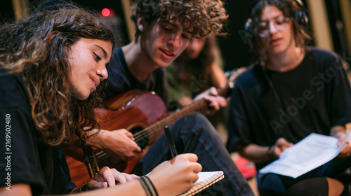 Group of Teenage Music Students Writing Songs Together With an Acoustic Guitar