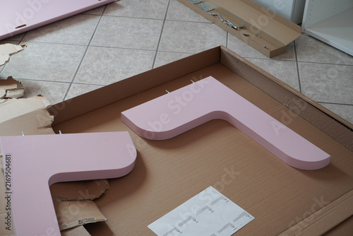 Assembling a pink children's bed. Furniture parts. Assembling furniture at home, using tools. Furniture repair and assembly. DIY concept with detailed view of furniture installation process. 