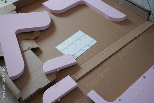 Assembling a pink children's bed. Furniture parts. Assembling furniture at home, using tools. Furniture repair and assembly. DIY concept with detailed view of furniture installation process. 