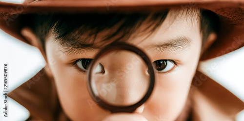 Curious child using a magnifying glass to closely observe details, representing exploration, discovery, and a desire to learn.