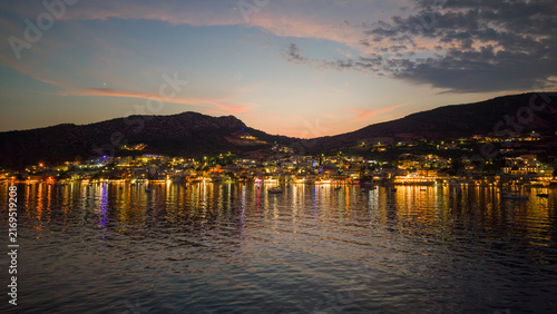 Aerial view of coastal town with lights reflection on calm sea water