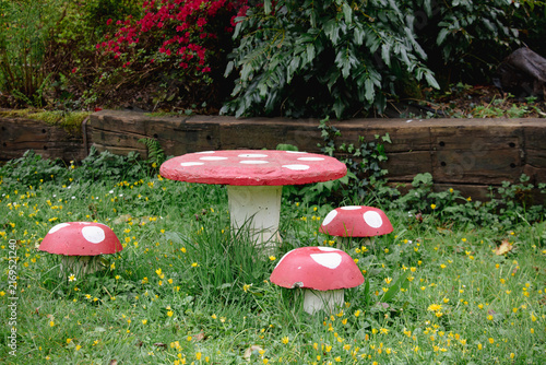 Fotografie Garden decoration featuring a large red and white toadstool table surrounded by