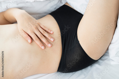 Hand Resting on Bare Abdomen in Bed