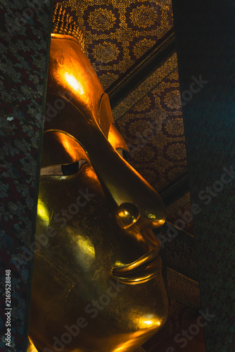 Photography Close-Up Face of Giant Golden Reclining Buddha Framed by Ornate Columns at Wat P