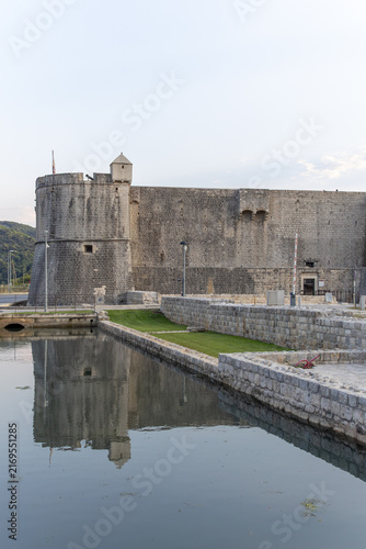 Obraz na płótnie Ancient medieval stone fortress Kaštio and defensive walls reflecting in a calm water canal at dusk