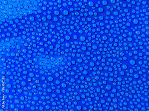 Obraz na płótnie Macro pattern of clear water droplets on bright blue surface background