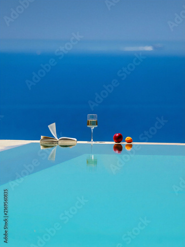 Obraz na plátne Minimal infinity pool terrace with white architecture overlooks the deep blue Aegean Sea, creating an iconic Mediterranean luxury travel scene ideal for resort and vacation advertising