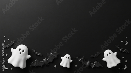 Halloween flat lay with white ghosts and black bats on a dark background