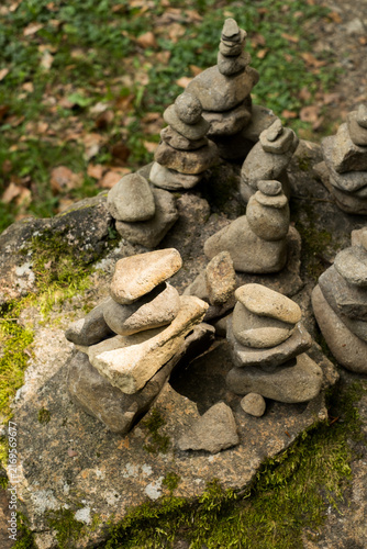 Photography Rock cairn stacks balanced on mossy boulder in forest for zen balance and mindfu