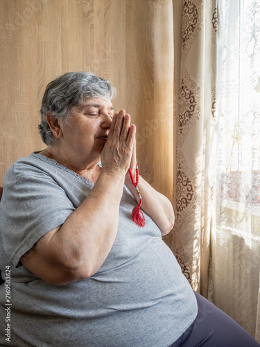 Canvas Print Senior Woman Praying with Hands Together at Home in Quiet Reflection