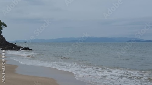 Tranquil Coastal Scene Featuring Soft Waves Under A Cloudy Sky