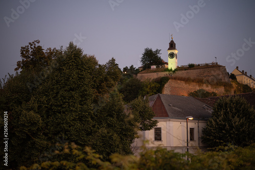 Obraz na płótnie illuminated clock tower stands atop the stone ramparts of Petrovaradin Fortress