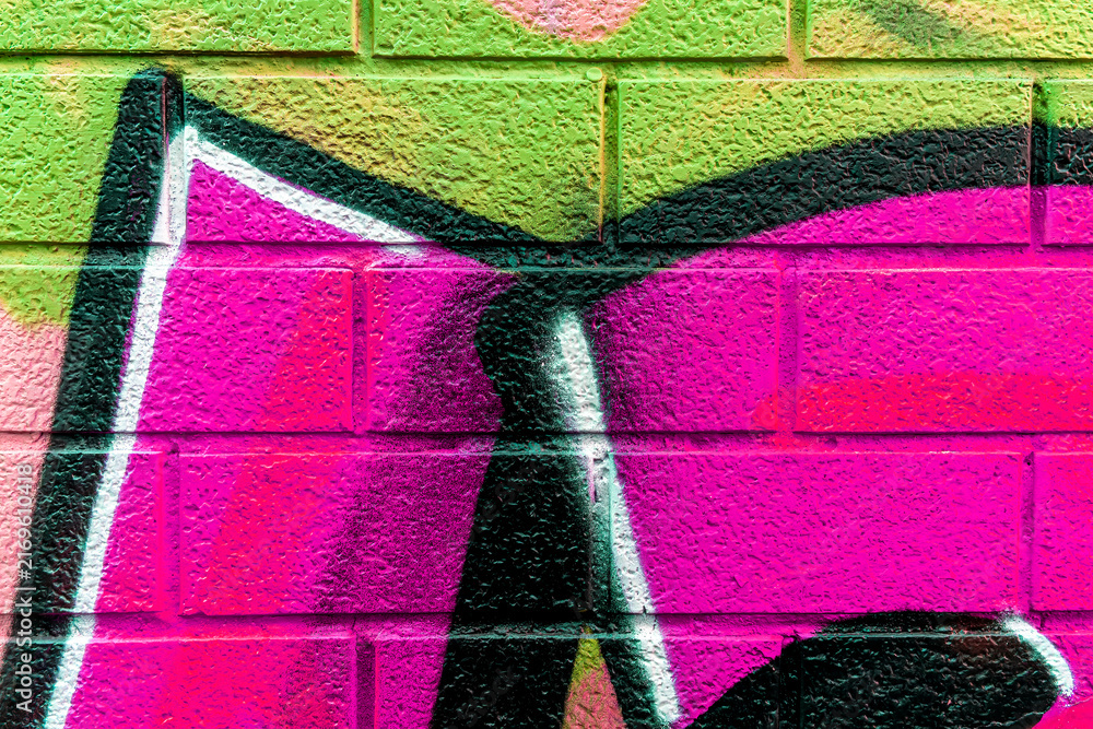 Fototapeta premium Beautiful brick wall colorful street art graffiti background. Abstract creative spray drawing fashion colors painting on the walls of the city. Urban Culture, aerosol texture