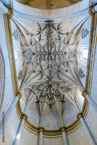 An ornate stone ribbed vault ceiling features intricate gothic tracery