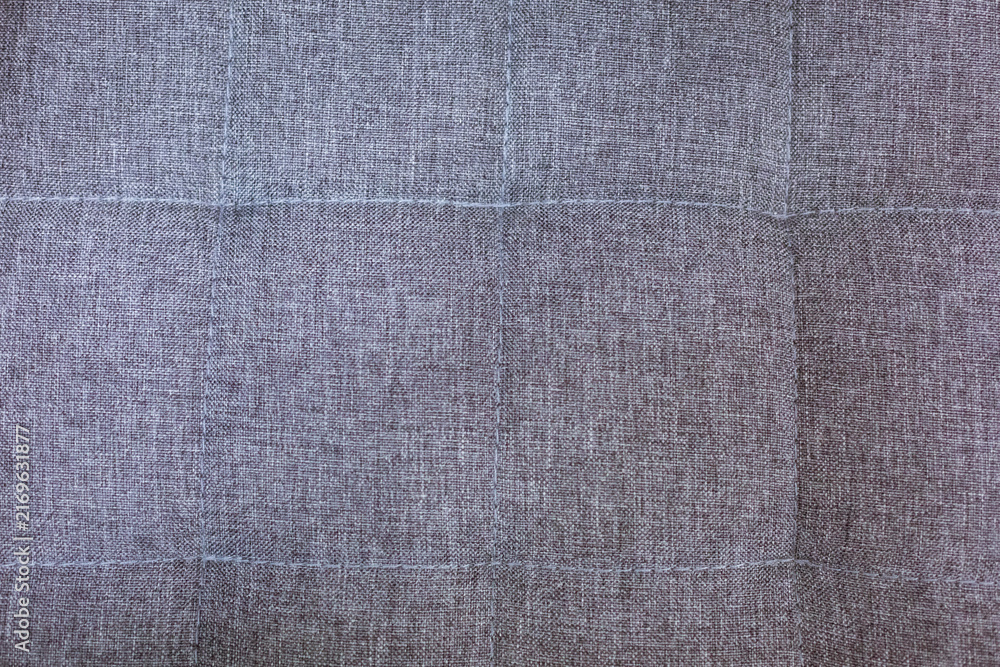 Naklejka premium Close up of grey woven upholstery fabric with stitched square seams, ideal for interior design, furniture and textile background content with copy space.