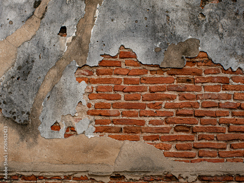 Cracked Plaster Wall Exposing Red Brick Underneath, Weathered Ruin Texture Background