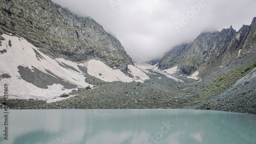 Photography Milky turquoise White Abudelauri Lake mirrors a snow-filled mountain cirque bene