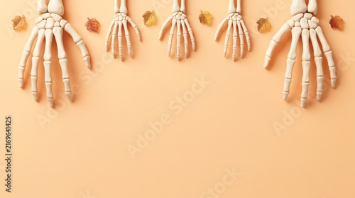 Top view of multiple human hand skeleton models arranged in a row on a soft beige background