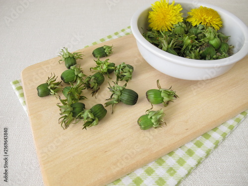 Fresh dandelion buds from the meadow on a wooden cutting board