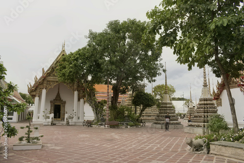 Konstfotografi lush courtyard garden with shade trees, traditional thai temple pavilions, and o