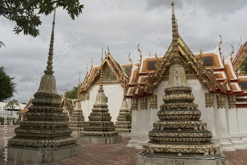 Foto rows of decorative ceramic tiled chedi stupas standing in stone courtyard beside
