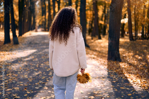 Woman walking through an autumn park.