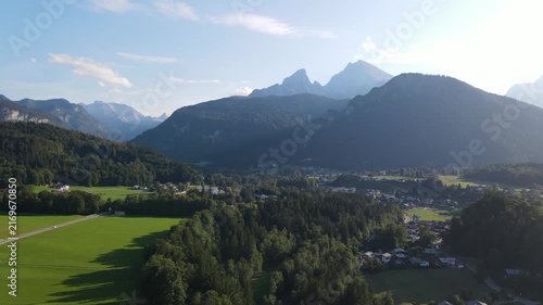 Aerial drone view of the iconic Watzmann mountain near Schönau am Königssee in Bavaria, Germany, featuring its distinctive twin peaks illuminated by warm sunset light. The majestic Bavarian Alps