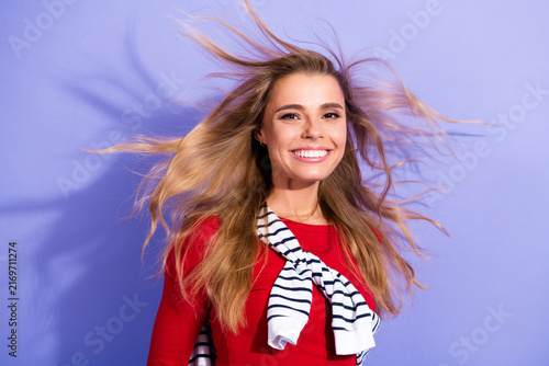 Foto Smiling young woman with windswept hair wearing red sweater and striped scarf ag