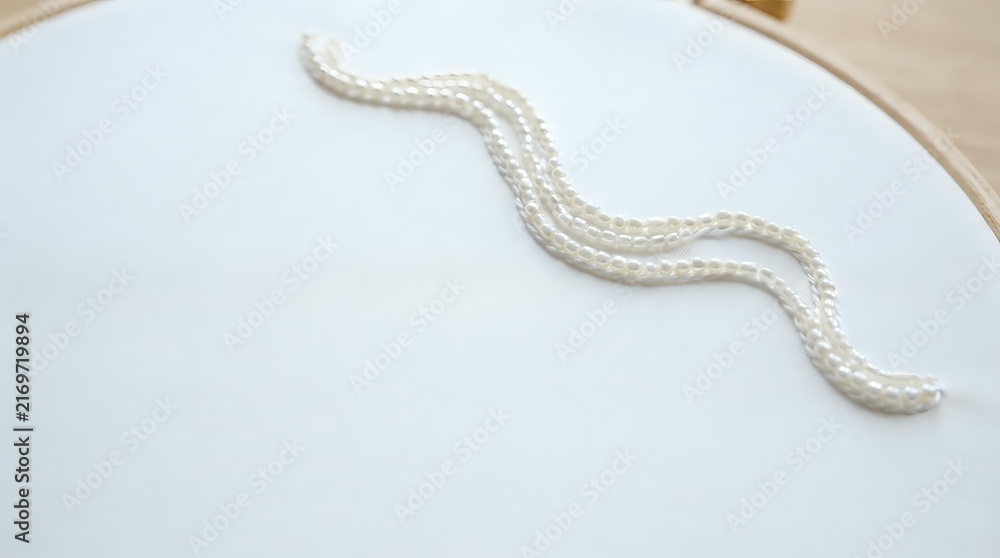 Fototapeta premium White twisted rope or cord arranged in a wavy S-shape on a clean