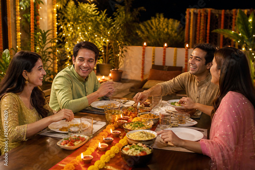 Diwali Feast: A joyous family celebrates Diwali, gathered around a richly laden table with traditional dishes and diyas, embodying warmth, togetherness, and the spirit of the festival of lights.