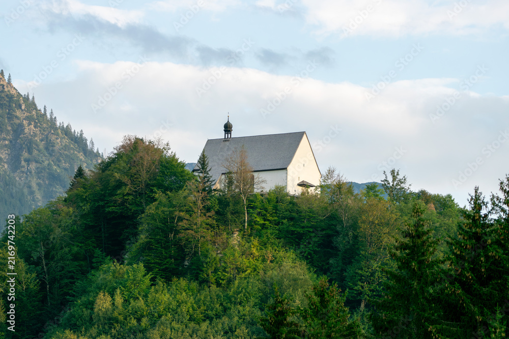 Fototapeta premium Historic Schöllang Burgkirche Church Surrounded by Forest in the Bavarian Allgäu