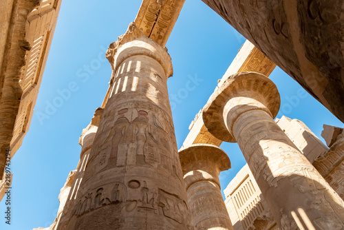 Canvastavla Tall columns with carvings in an ancient temple under a blue sky